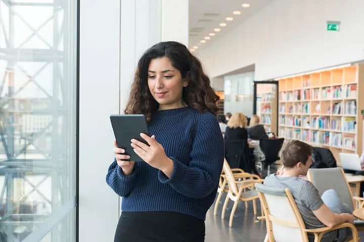 Person reading on a tablet in a library