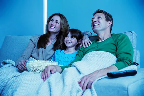 Family enjoying a movie night on the couch